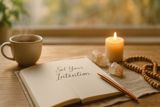 Open journal withSet Your Intention" written, beside candle, crystals, and tea.