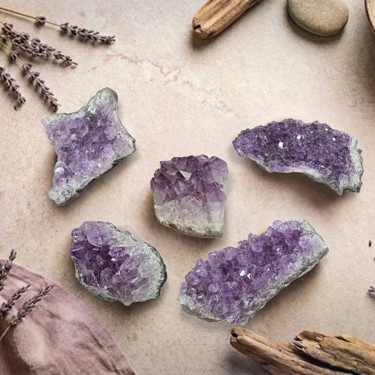 Assorted Brazilian Amethyst Geode Cluster Pieces 50–100g displayed on a natural background, perfect for spiritual decor or crystal healing.