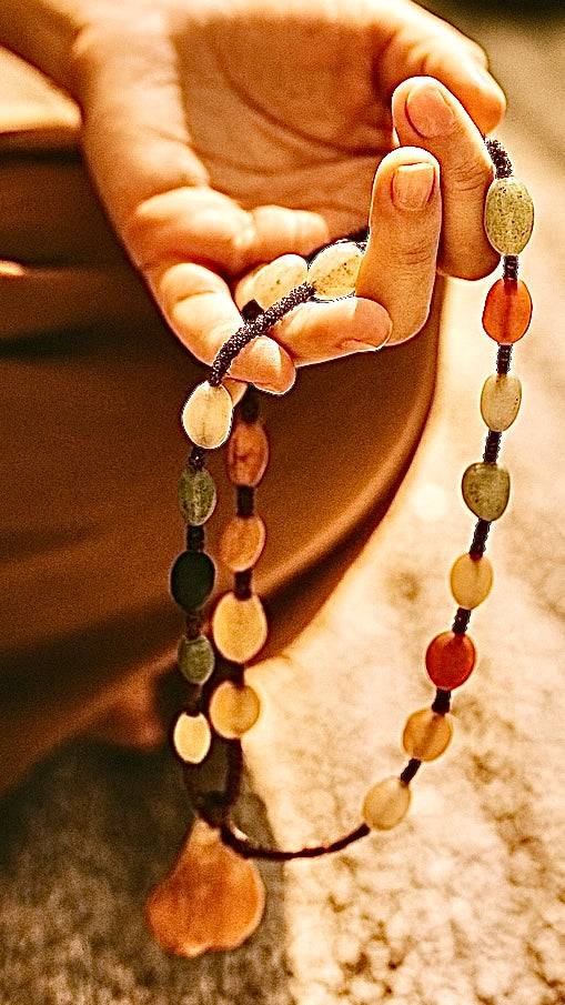Close-up of polished Gobi Desert Agate beads with unique desert patterns, hand knotted cord