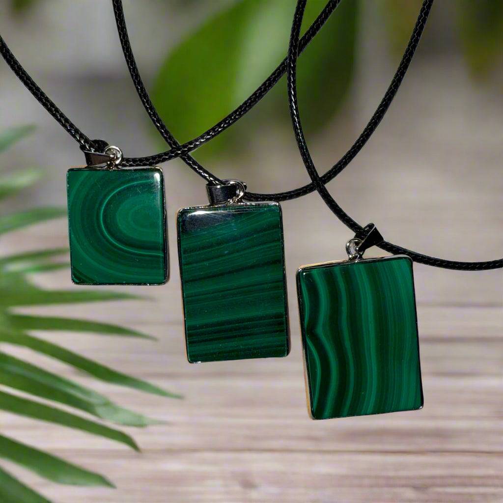 Back view of a rectangular malachite pendants showing vivid green banding and polish