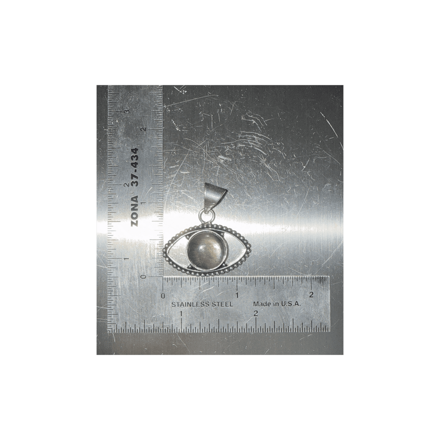 Labradorite Evil Eye Pendant with central gemstone set in silver, symbolizing transformation and protection, shown with ruler for size reference.