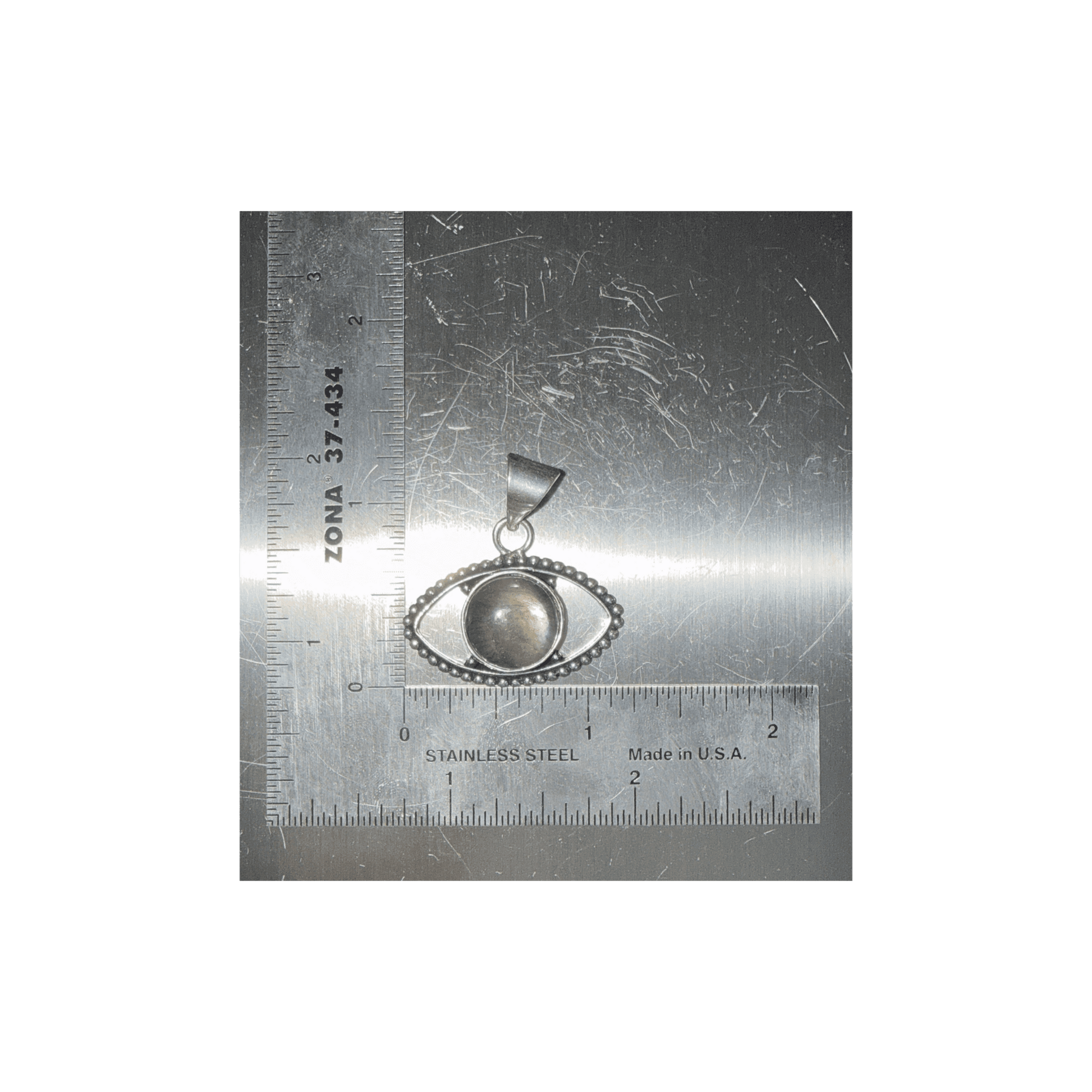 Labradorite Evil Eye Pendant with central gemstone set in silver, symbolizing transformation and protection, shown with ruler for size reference.