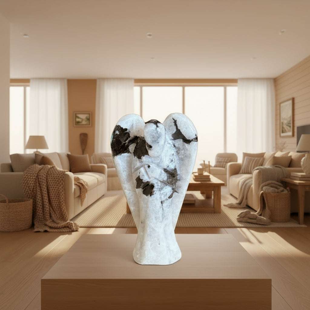 Rainbow Moonstone angel statue on a wooden surface with living room in the background