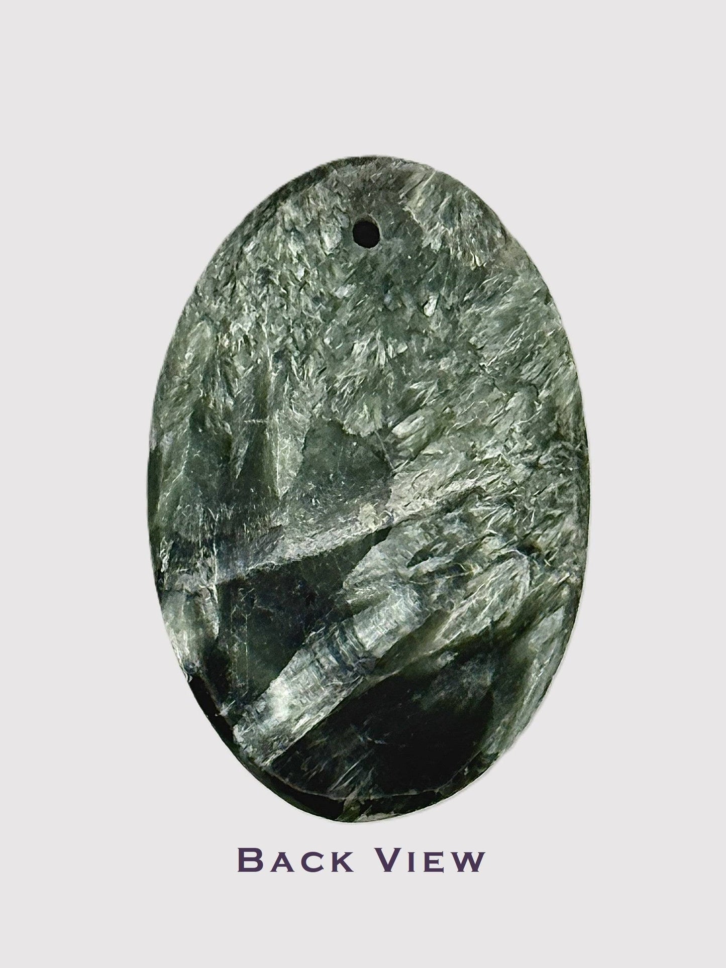 Close-up of polished Seraphinite gemstone oval cabochon - back view
