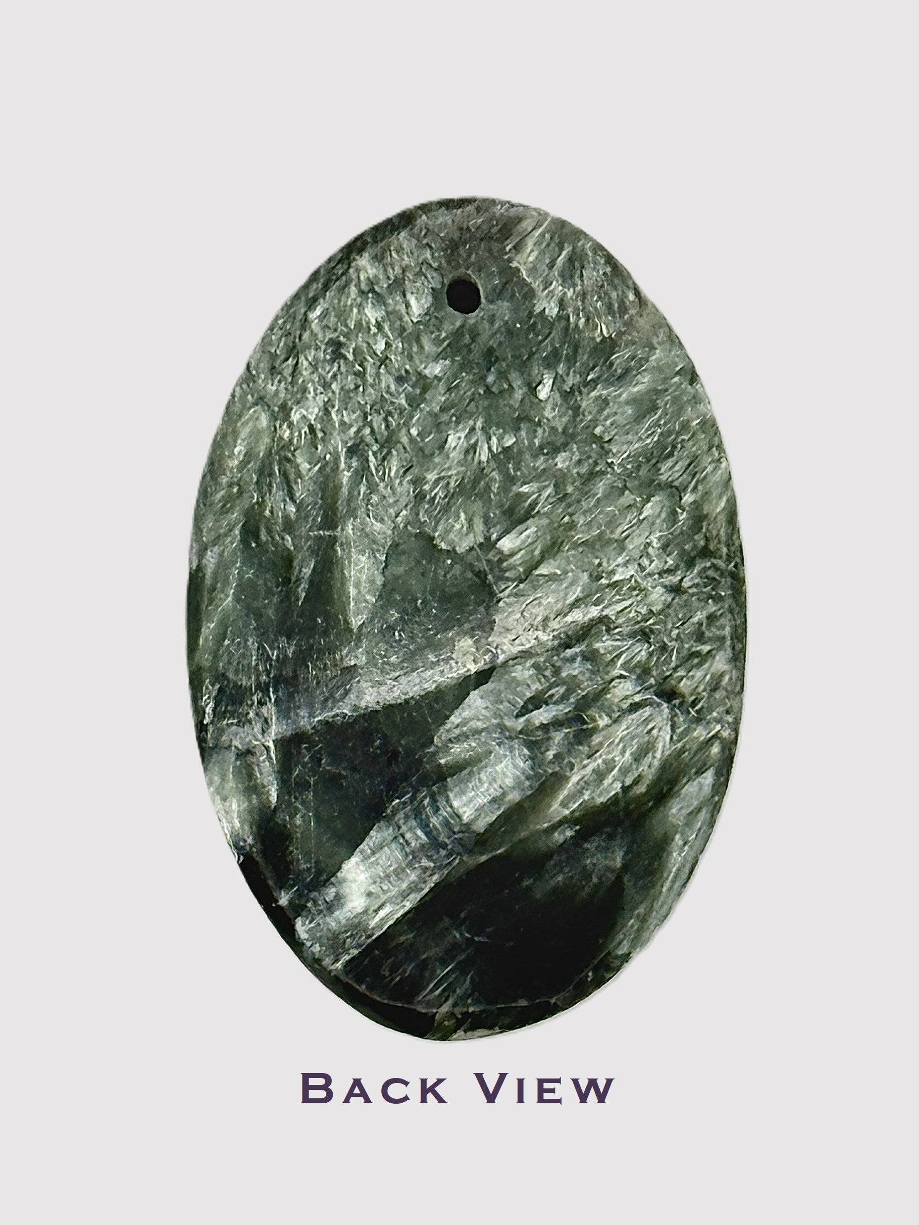 Close-up of polished Seraphinite gemstone oval cabochon - back view