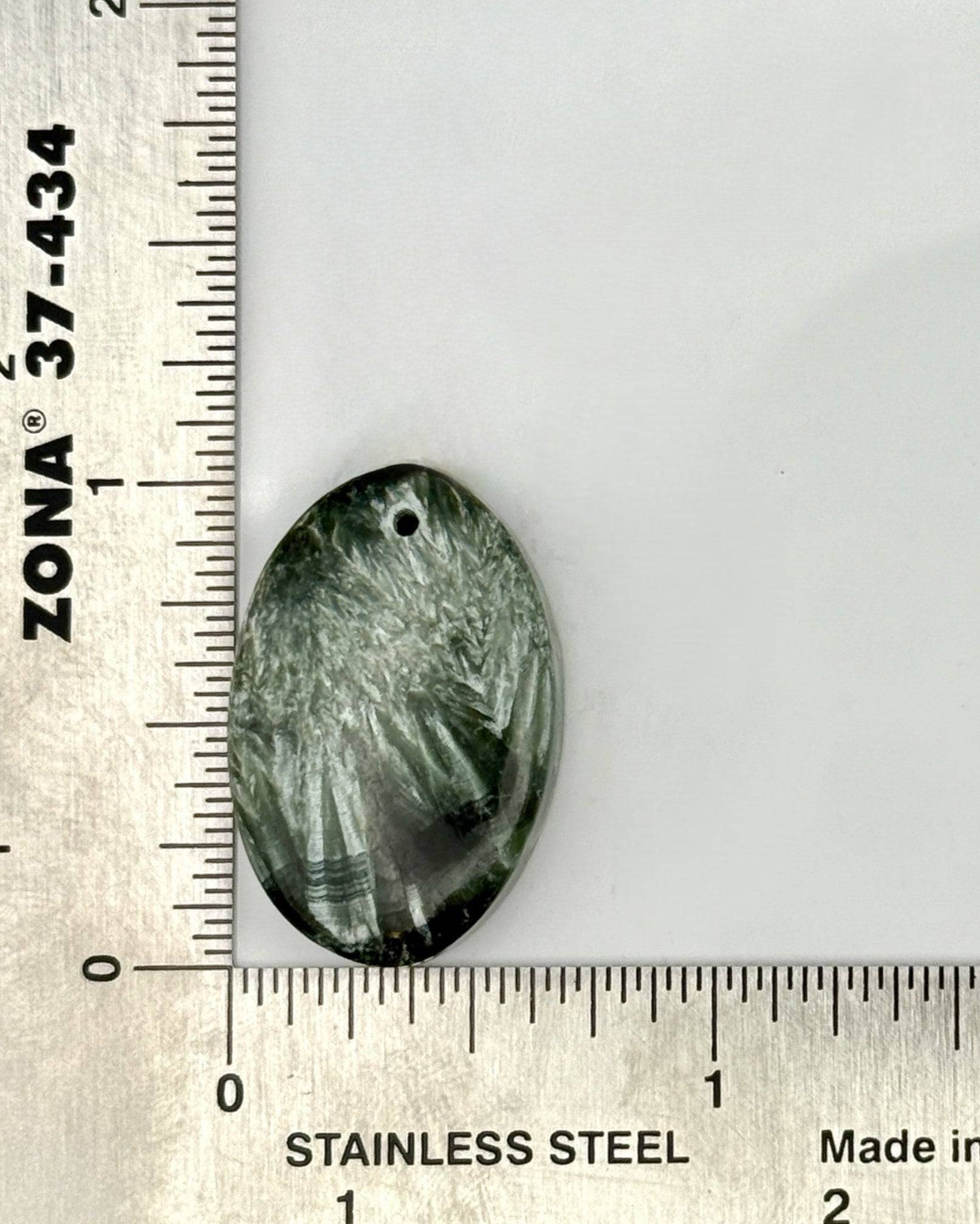 Shimmering Seraphinite cabochon with chatoyant silver flashes