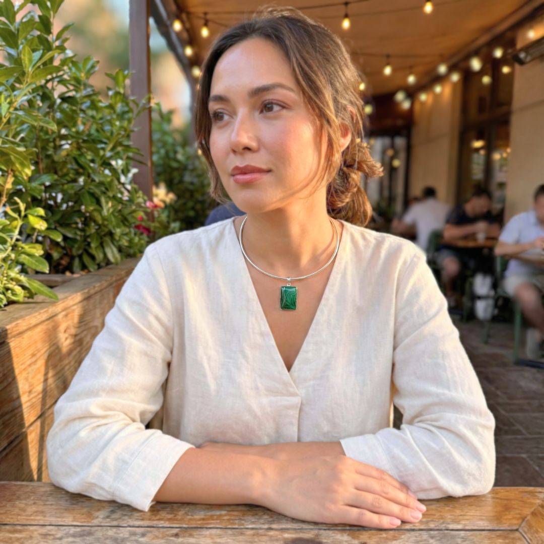 Woman wearing sterling silver plated adjustable choker with green pendant, showcasing minimalist collar style in a casual outdoor setting.