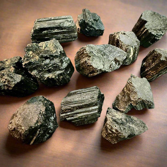 Flat-lay set of multiple raw black tourmaline specimens on a dark background, showing varied shapes and textures, 50g–120g.