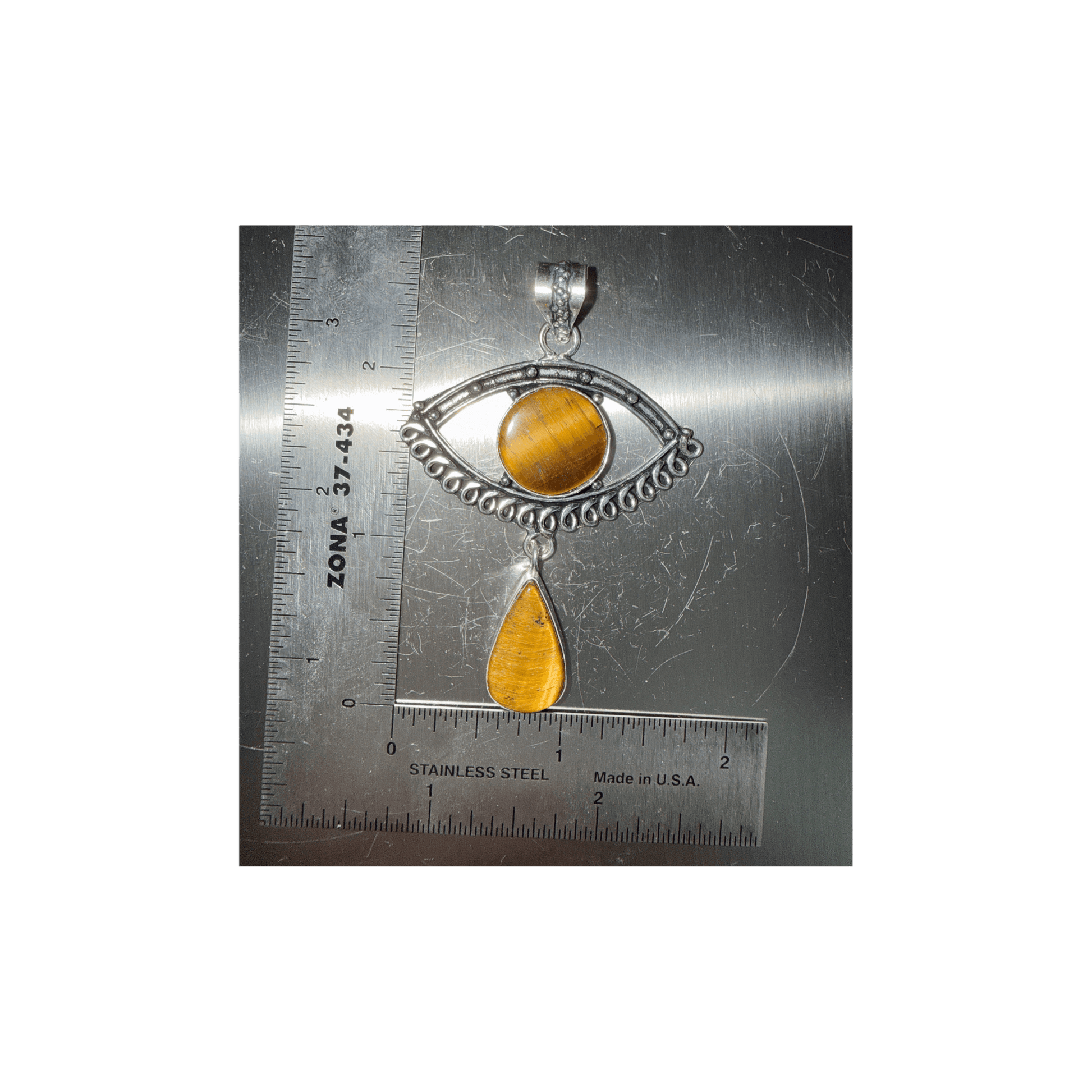 Tigers Eye Evil Eye Drop Pendant in Sterling Silver featuring a round eye design with a teardrop charm, shown next to a ruler for scale.