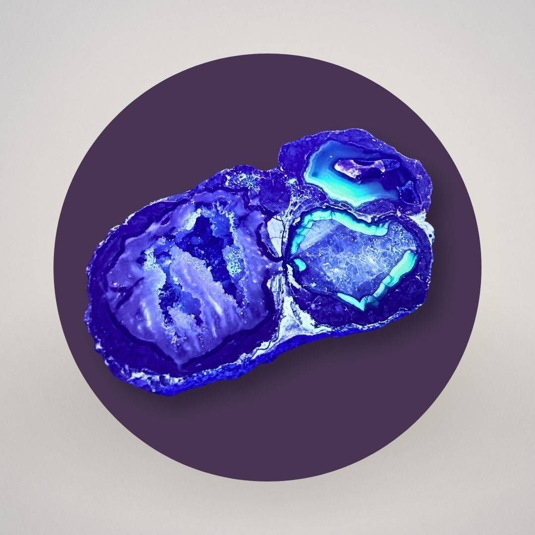 Baker Agate thunderegg half under long-wave UV light showing fluorescent response in the agate chambers.