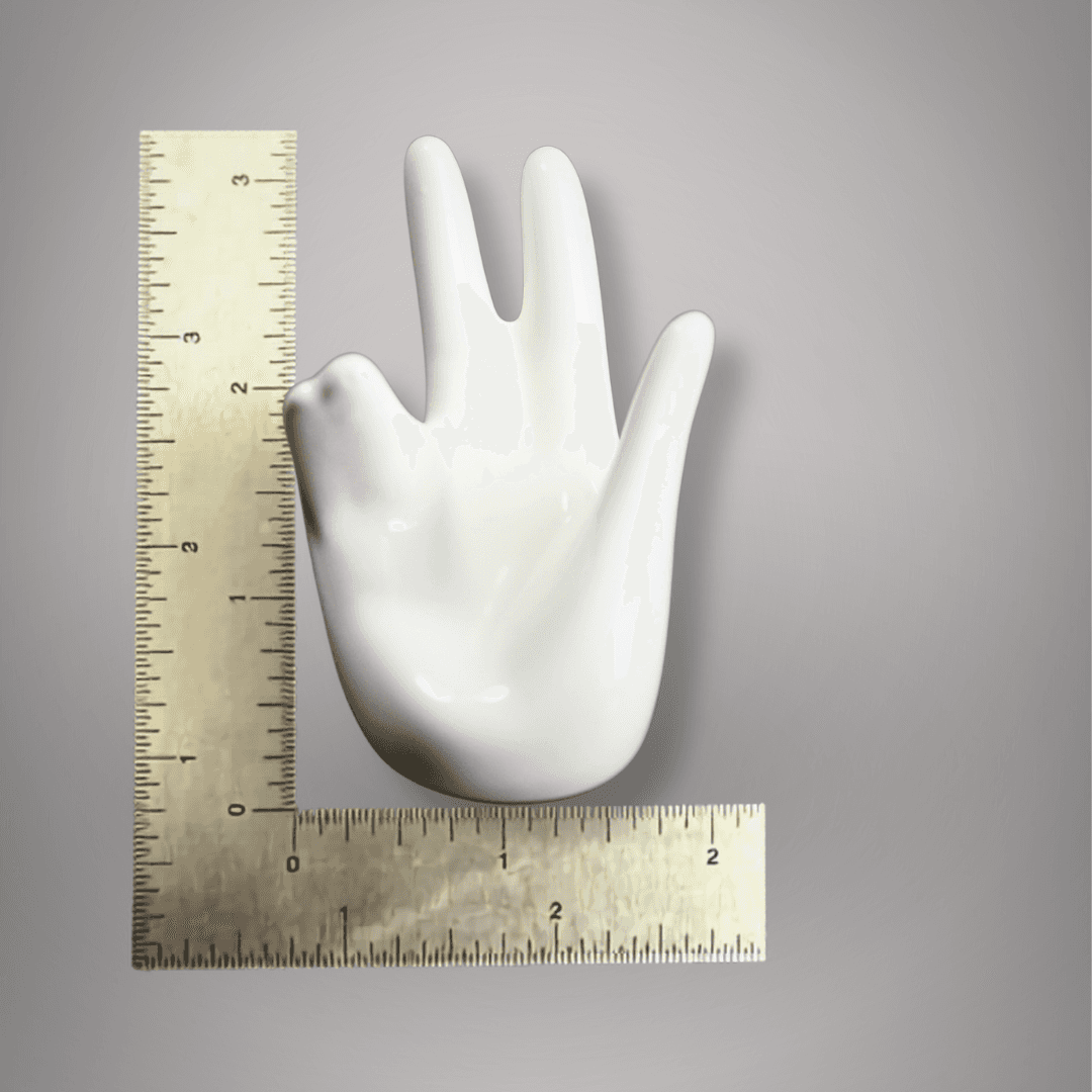 White ceramic hand sphere stand displayed beside inch rulers showing its approximately 3-inch height and 2-inch width.