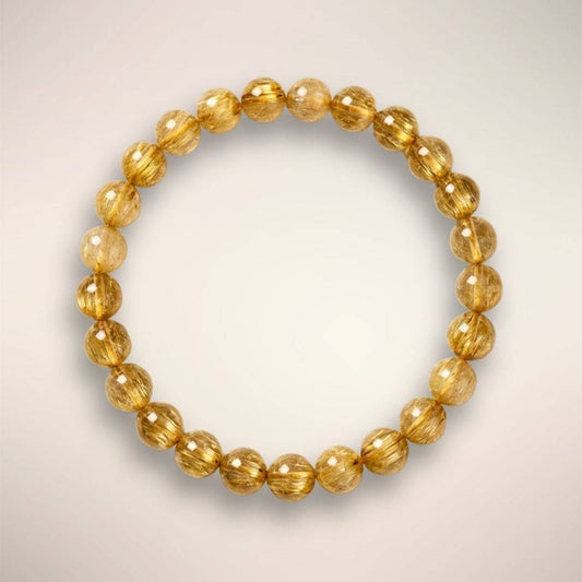 Golden Rutile Quartz 6mm beaded bracelet displayed on a clear stand, for clarity and intuitive flow.