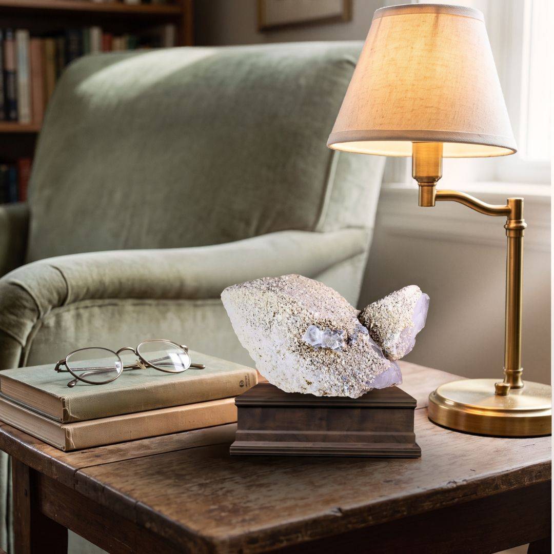Quartz with scheelite and fluorite specimen displayed on a dark mineral stand in an interior setting.