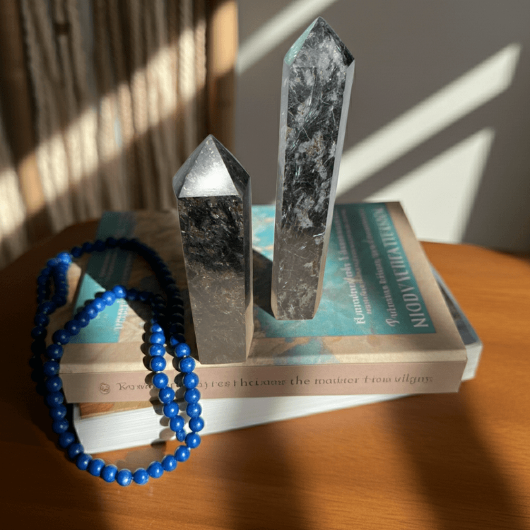 Arfvedsonite Generator - Manifestation & Clarity | Natural Polished Energy points displayed on books with sunlight, ideal for gemstone collectors.