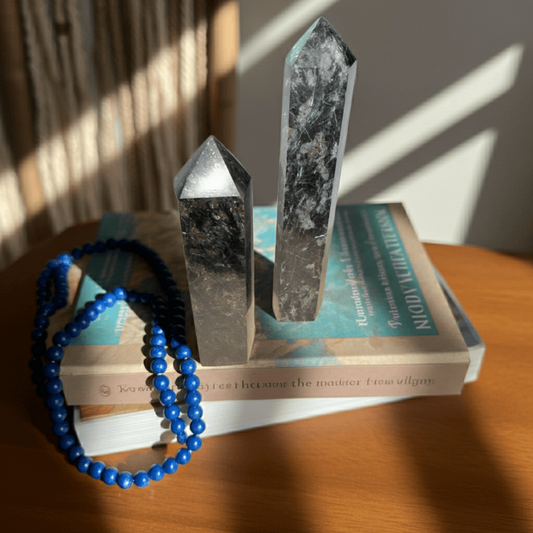 Arfvedsonite Generator - Manifestation & Clarity | Natural Polished Energy points displayed on books with sunlight, ideal for gemstone collectors.