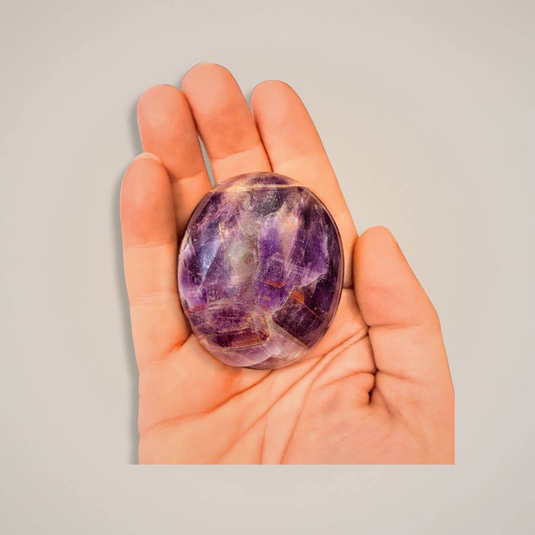 Purple gemstone palm stone held in hand, Alien Amethyst with violet tones