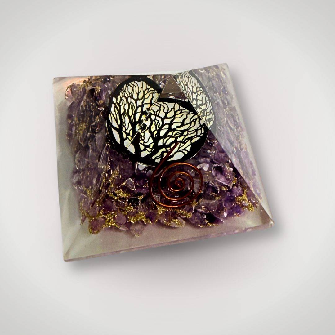 Angled view of Amethyst Tree of Life Orgonite Pyramid featuring copper spiral and gemstone layers for calming energy and ritual decor.