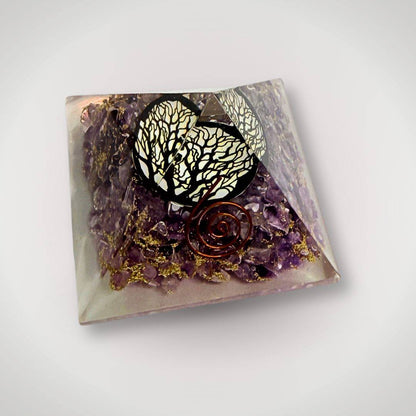 Angled view of Amethyst Tree of Life Orgonite Pyramid featuring copper spiral and gemstone layers for calming energy and ritual decor.