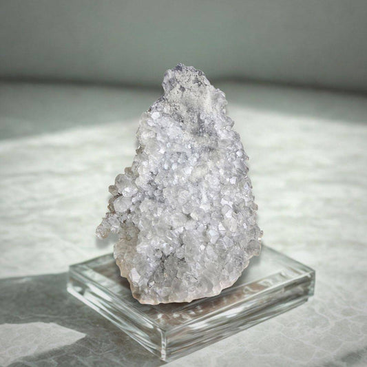 Apophyllite Cluster - Collector Specimen 497g displayed on a clear stand, highlighting its sparkling facets and natural light reflection.