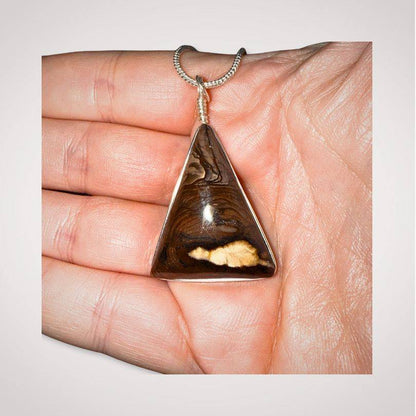 Biggs Jasper triangle pendant jewelry in hand for scale