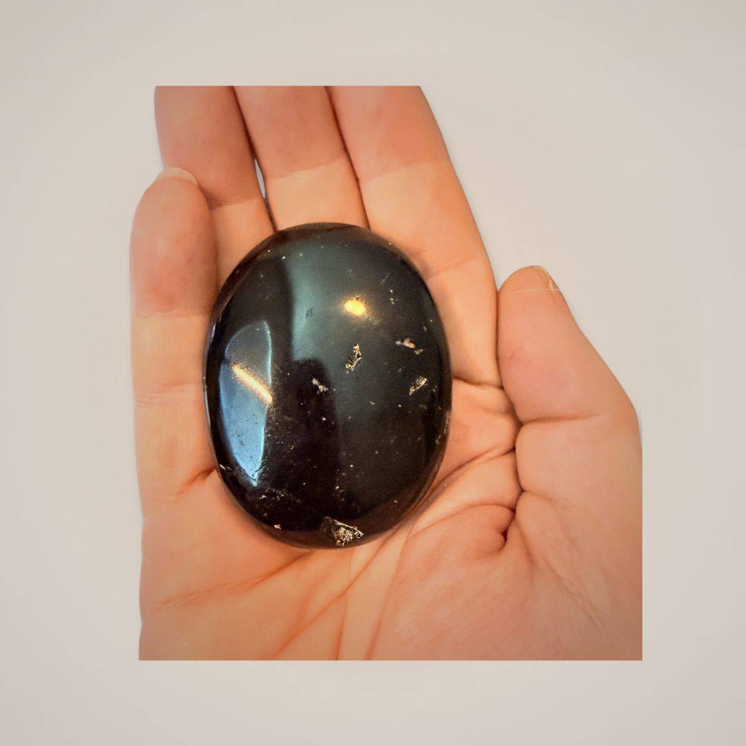 Black Tourmaline Palm Stone in hand for meditation