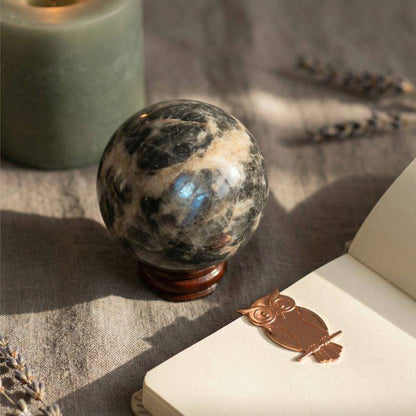 Soulful Black Moonstone Sphere with shimmering surface on wooden stand, ideal for intuition and meditation rituals in crystal healing collections.