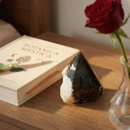 Bloodstone polished point tower displayed on a wooden nightstand beside a book and rose, perfect for emotional strength and décor.
