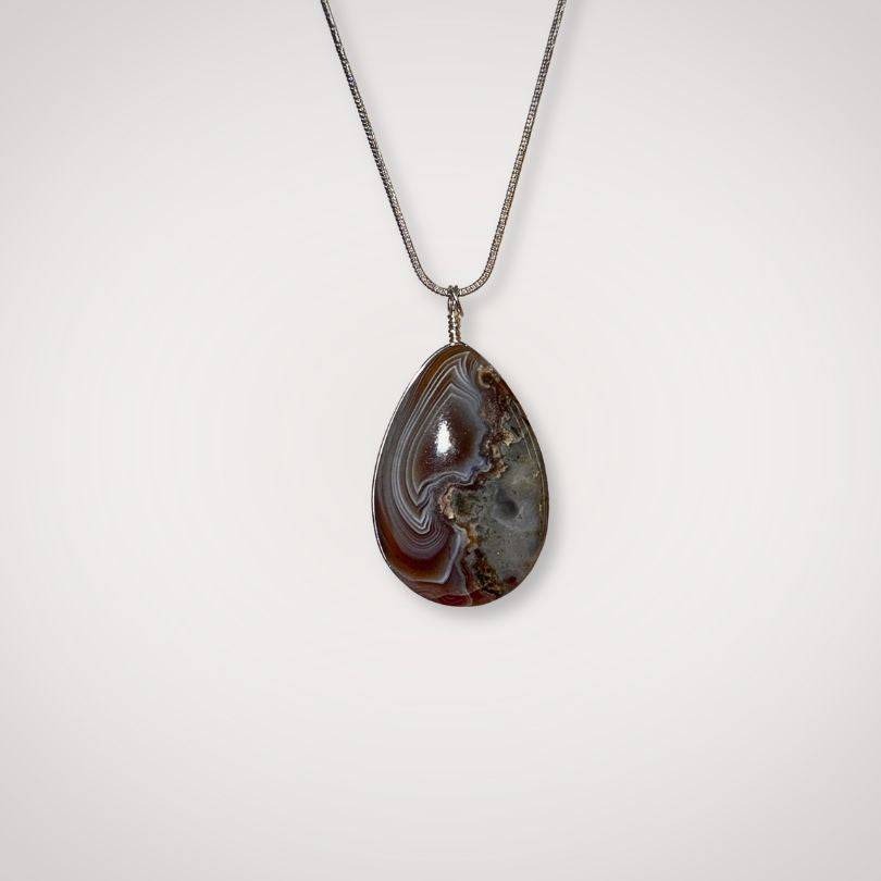 Botswana Agate pendant with silver chain on white background