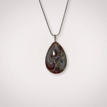Botswana Agate pendant with silver chain on white background