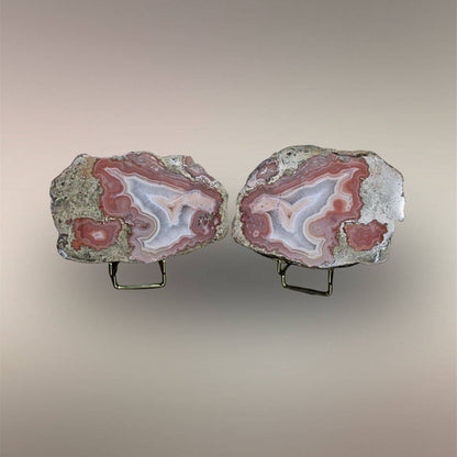 Bou Hamza Agate pair displayed open with mirrored rose-white banding, quartz interiors, and druzy centers.
