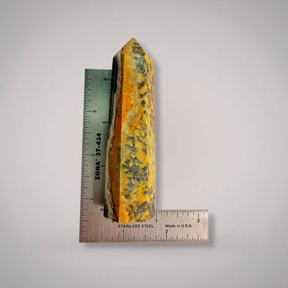 100mm Bumblebee Jasper Tower measured against a stainless steel ruler, showcasing size and vibrant patterns for collectors and crystal enthusiasts.