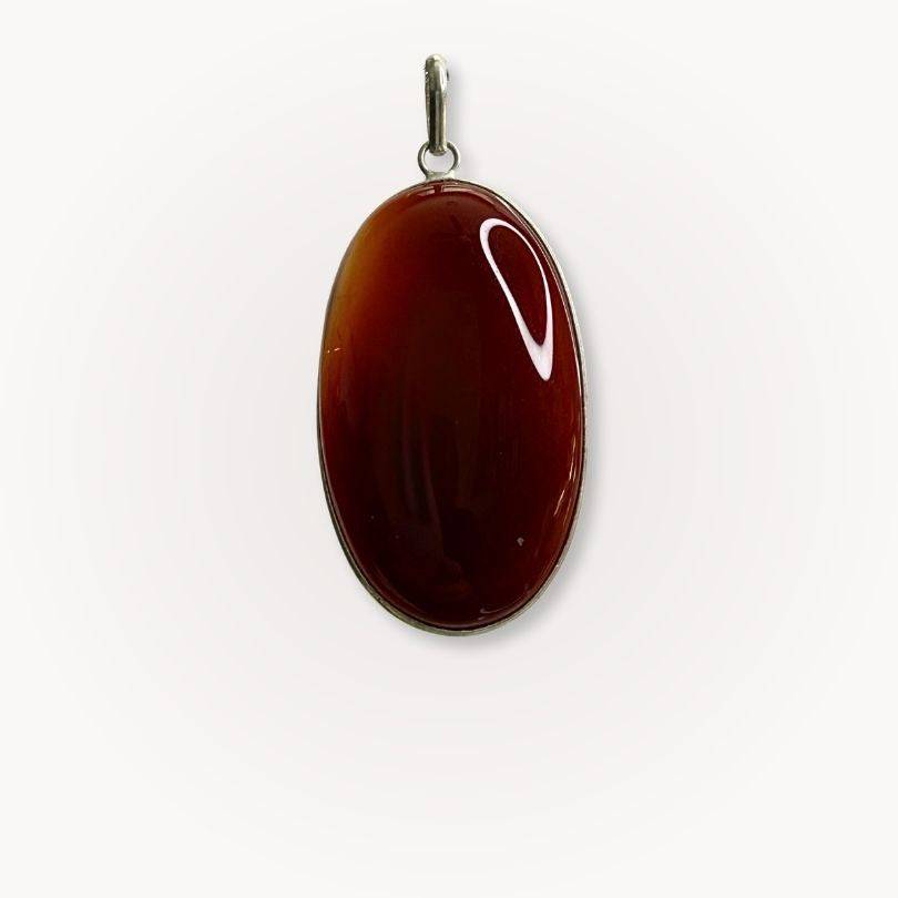 Close-up of Carnelian Statement Pendant featuring a polished oval gemstone in silver plate, radiating vibrant energy for motivation and creativity.
