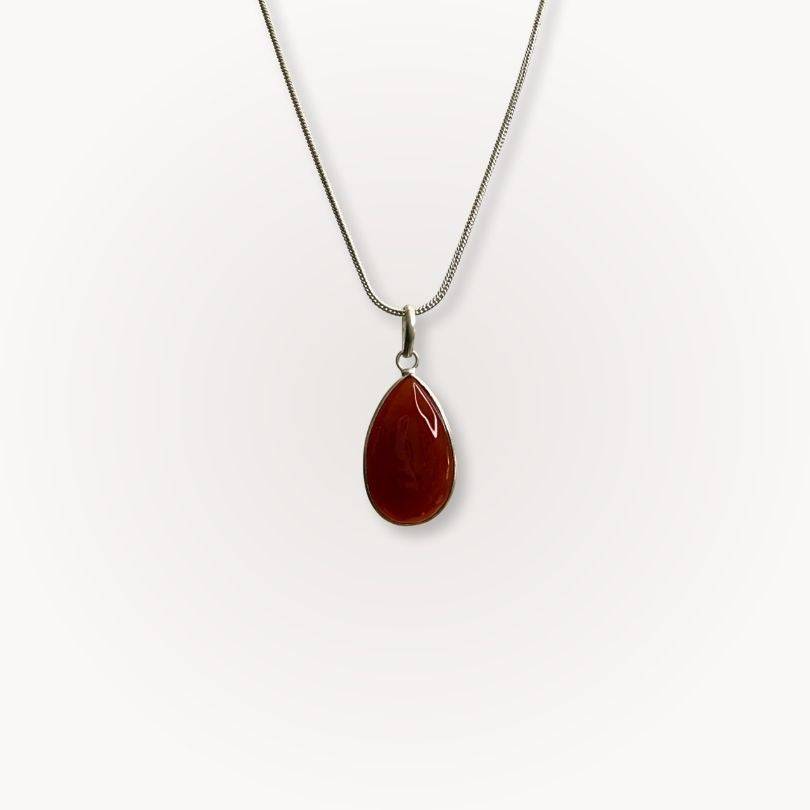 Carnelian Classic Pendant with teardrop shape on silver chain, showcasing warm red-orange crystal for confidence and vitality.