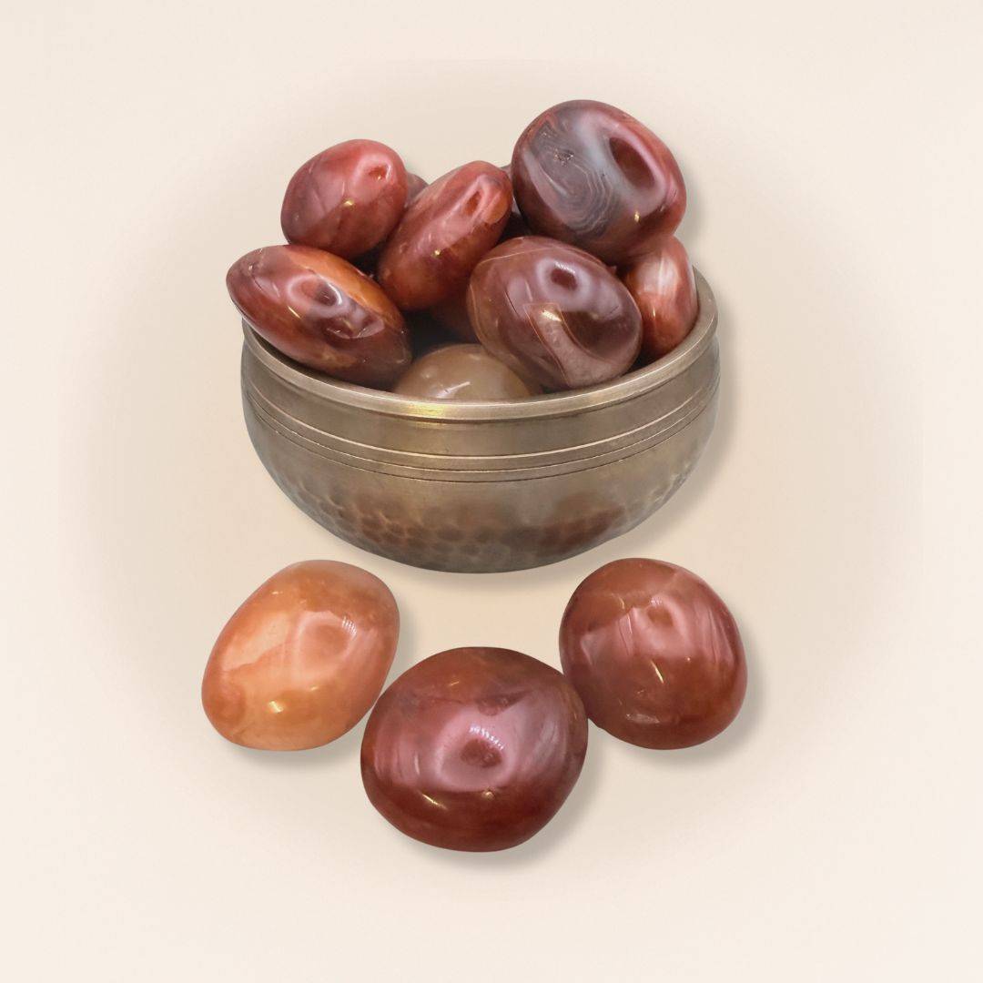 Collection of Carnelian Tumbled Stones in a decorative brass bowl, perfect for unique home decor and empowering creative energy.