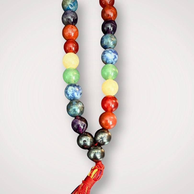 Close-up of Chakra Mala Necklace with multicolored natural stones and tassel, designed for energetic alignment and mindfulness in spiritual practice.