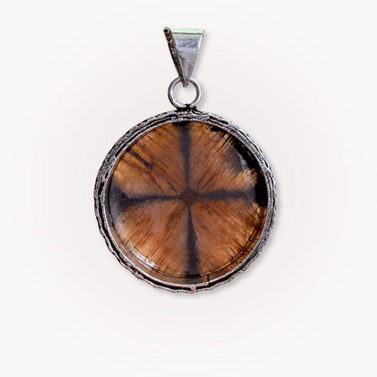 Detailed view of a round Chiastolite Cross Stone Pendant with silver setting, featuring the distinct cross formation symbolic of sacred balance.