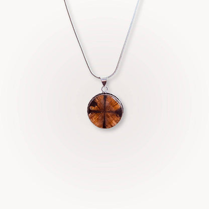 Single round Chiastolite Cross Stone Pendant on a silver necklace, highlighting its earthy tones and sacred cross formation for grounding energy.