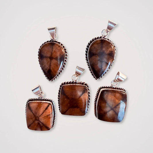 Chiastolite Cross Stone Pendants in teardrop and square shapes with silver trim, showcasing natural cross patterns for spiritual grounding.