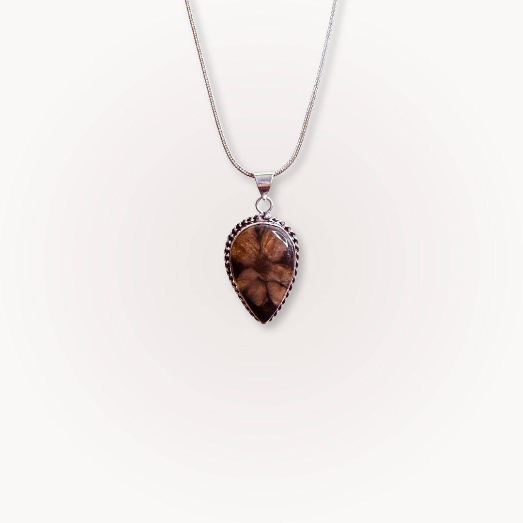 Single teardrop Chiastolite Cross Stone Pendant on a silver necklace, featuring a distinct natural cross pattern for spiritual balance.