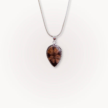 Single teardrop Chiastolite Cross Stone Pendant on a silver necklace, featuring a distinct natural cross pattern for spiritual balance.