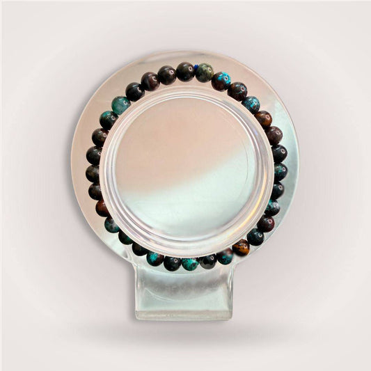 Peruvian Chrysocolla 6mm Beaded Bracelet displayed on a clear round stand, showcasing its calming heart energy and natural gemstone tones.