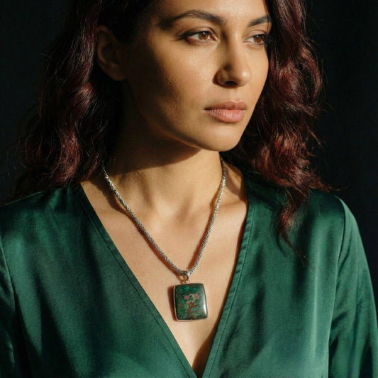 Woman wearing Chrysocolla Pendant for Calm & Heart Healing by Mystic Parcel, featuring a square green and copper gemstone on a silver chain.