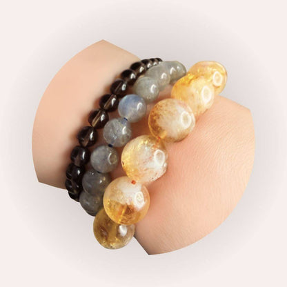 Citrine Bracelet 12mm worn on wrist with other crystal bracelets, highlighting its vibrant yellow hue and joyful energy in a stacked style.