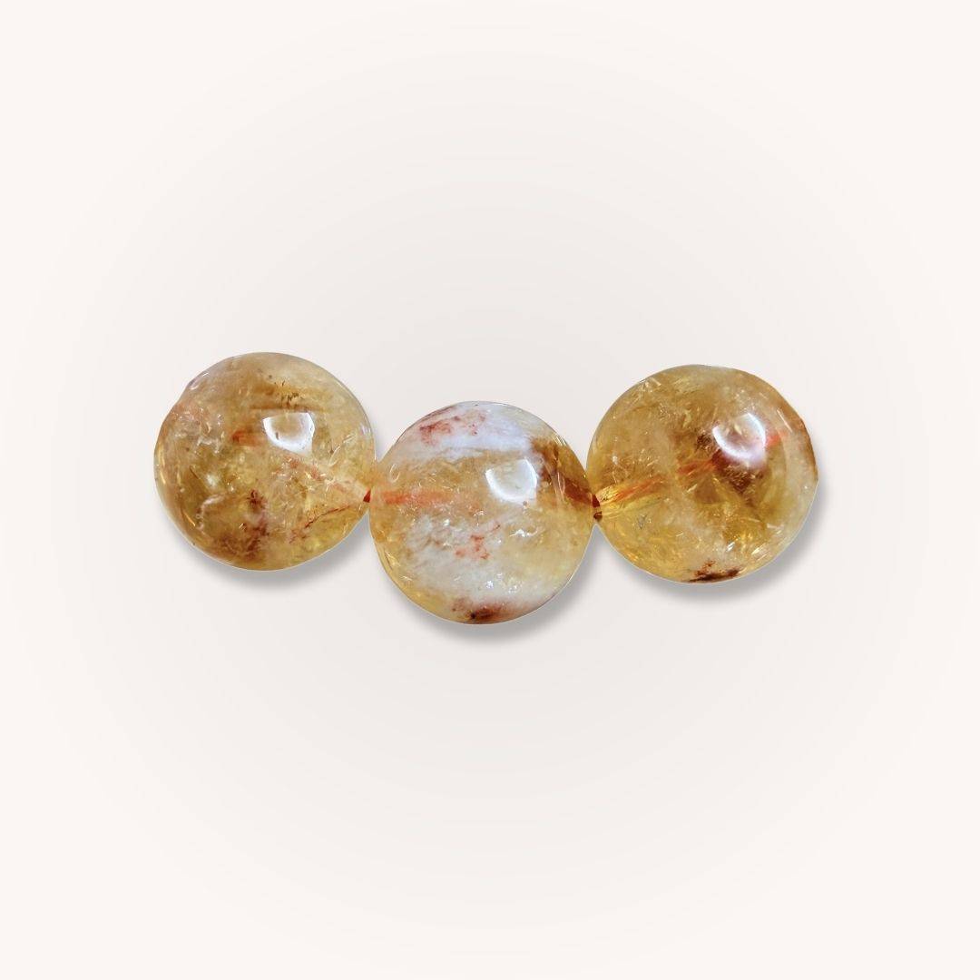 Close-up of three 12mm Brazilian Citrine beads showcasing natural inclusions and golden clarity, ideal for crystal jewelry lovers.