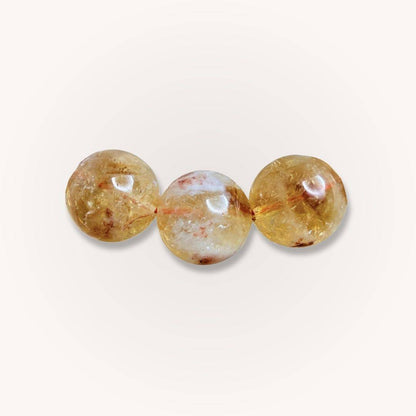 Close-up of three 12mm Brazilian Citrine beads showcasing natural inclusions and golden clarity, ideal for crystal jewelry lovers.
