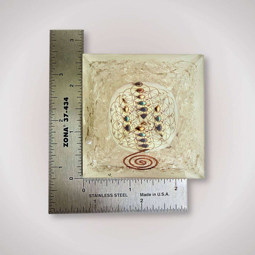 Clear Quartz Flower of Life Orgonite Pyramid measured with ruler, showing compact size for versatile home and ritual use.