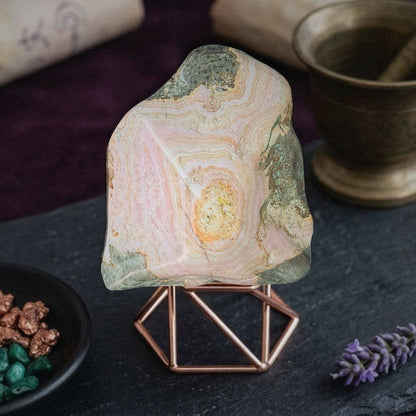 Pink and green Cobaltoan Calcite stalactite on display stand with natural cave patterns
