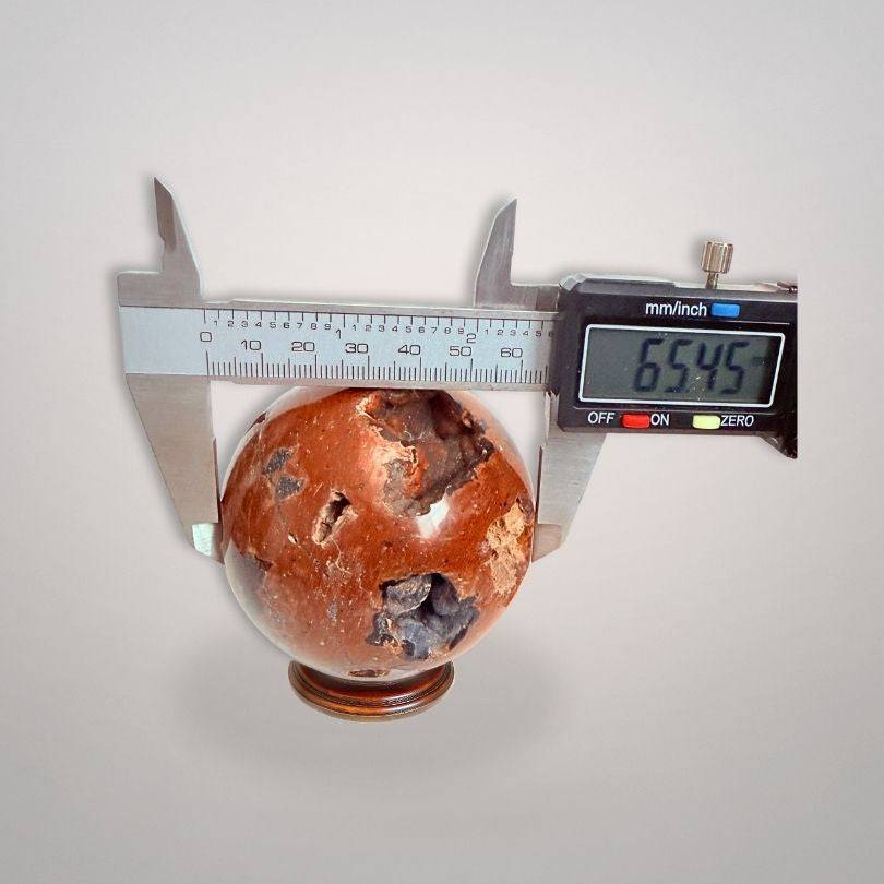 Red Fox Agate Sphere (346g) measured at 65.45mm diameter with caliper, emphasizing its size and collectible mineral quality.