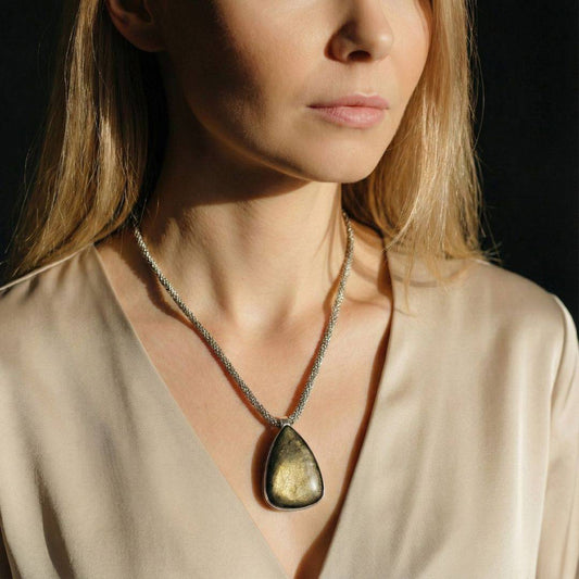 Gold Sheen Obsidian Pendant worn on a silver chain, ideal for empowerment and shadow work jewelry. Elegant teardrop shape with golden shimmer.