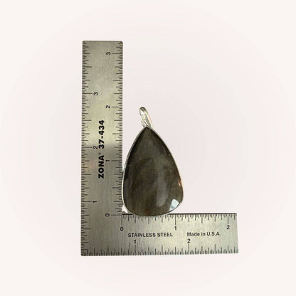 Teardrop Gold Sheen Obsidian Pendant next to ruler for size reference. Empowering jewelry piece for shadow work and spiritual clarity.